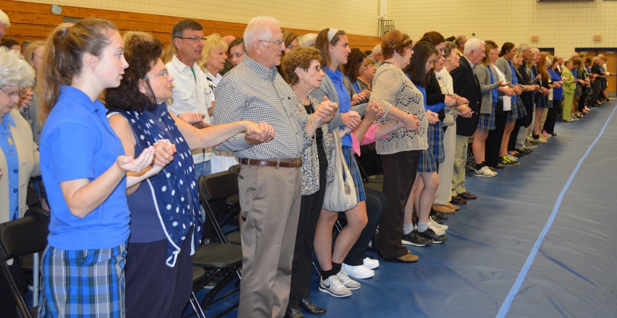 Glory and Praise: Grandparents join hands with their Marian granddaughters at Mass on the morning of Oct. 8. More than 700 grandparents joined the girls for the day’s festivities. photo by emily mckenna